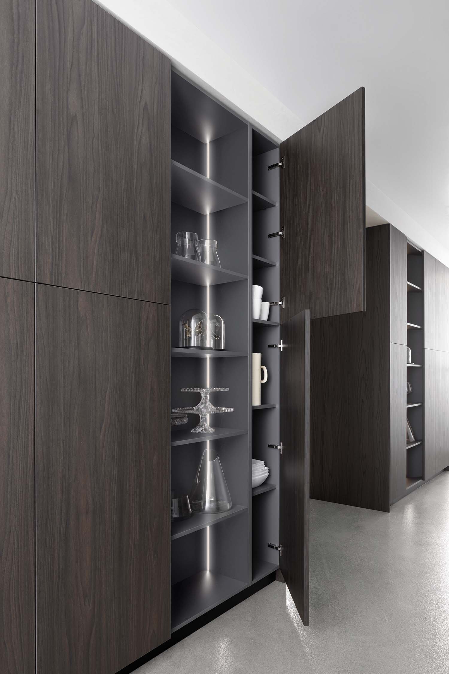 The tall units used from the living and dining room side are characterised by a projecting door that partially covers the adjacent open shelving.