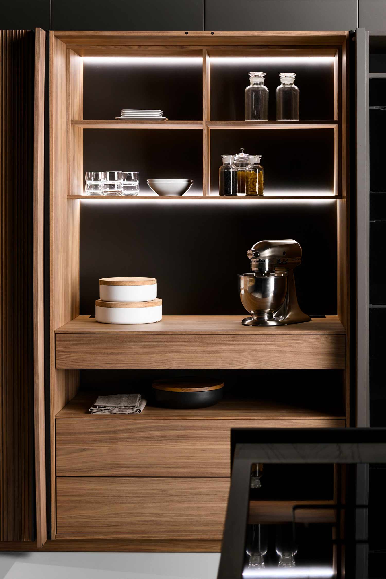 Concealed kitchen units and storage within the luxury walnut veneer kitchen tall units.