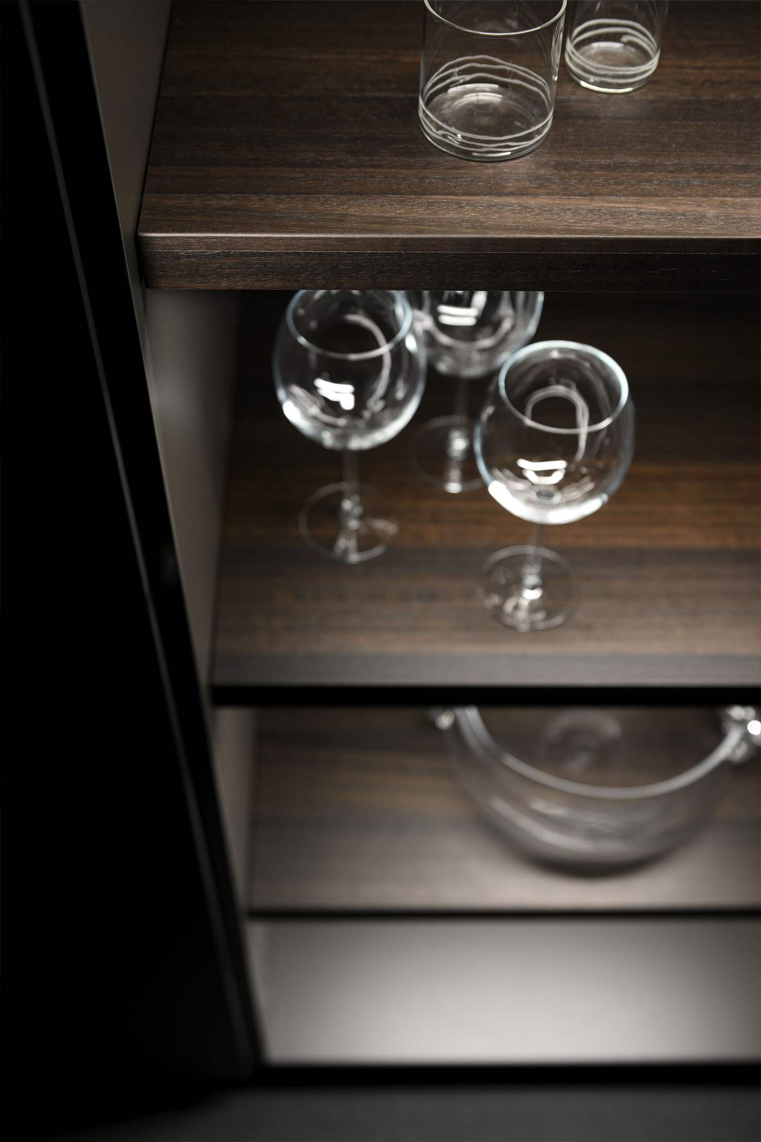 Luxury glass kitchen tall units finished in smoked Eucalyptus wood veneer and smoked glass.