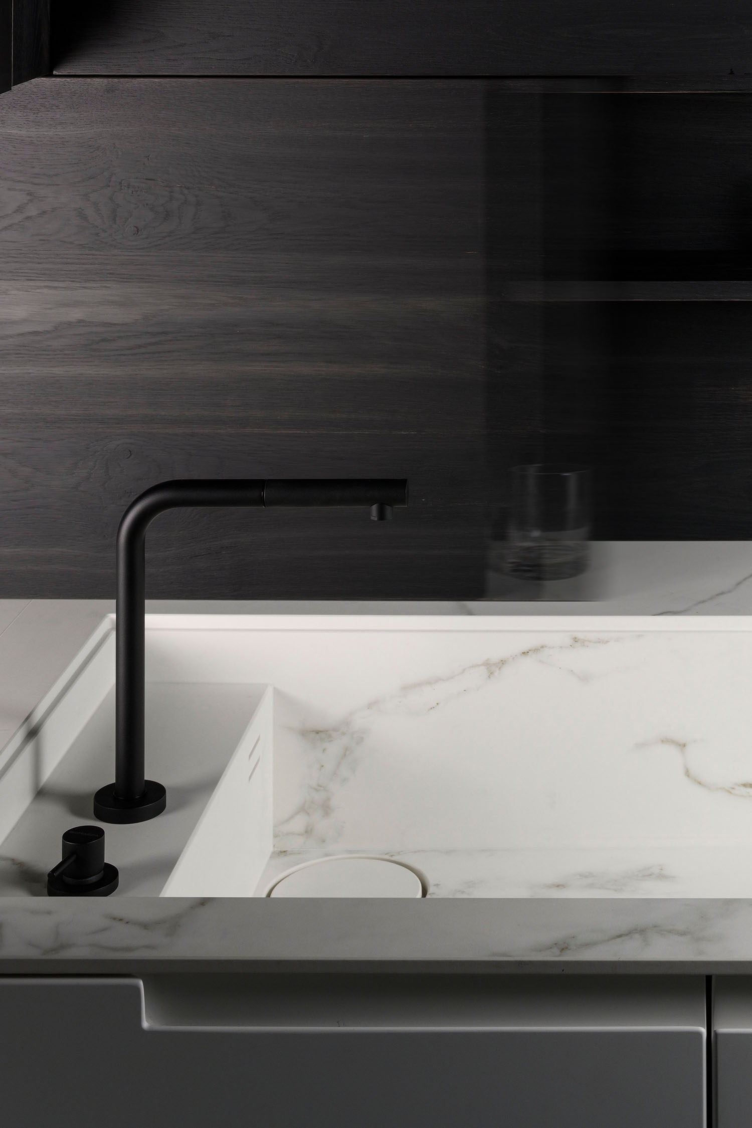 Marble intergrated sink with contrasting black metal kitchen tap.
