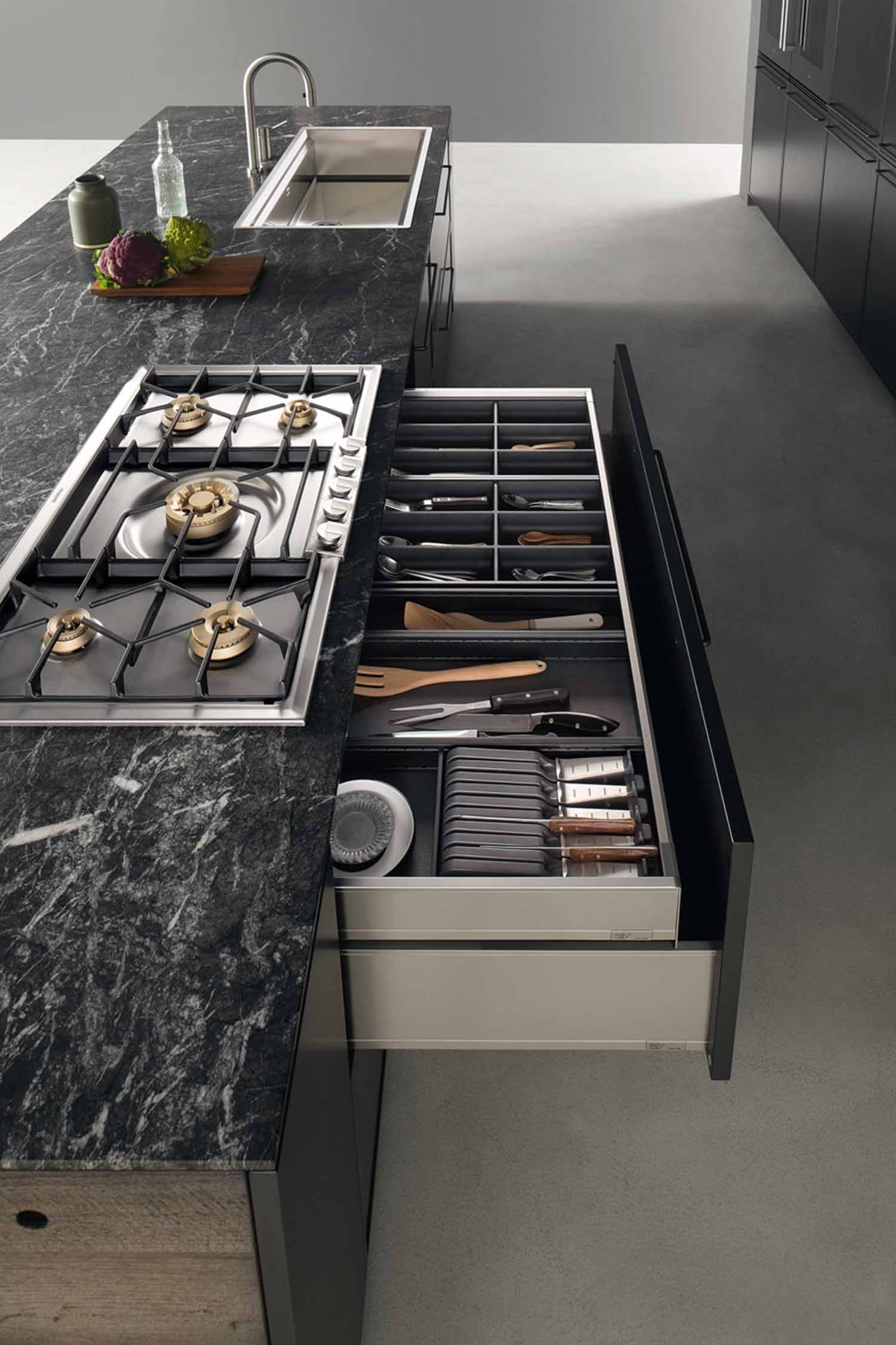 Multi-functional extra-wide deep drawers host dividers and organisers to contain all kitchen essentials close to the cooking area.