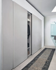 Luxury Italian sliding wardrobe with full-height handle grip. Available to be installed set against a wall, recessed or on a wall corner. Designed and install by Krieder
