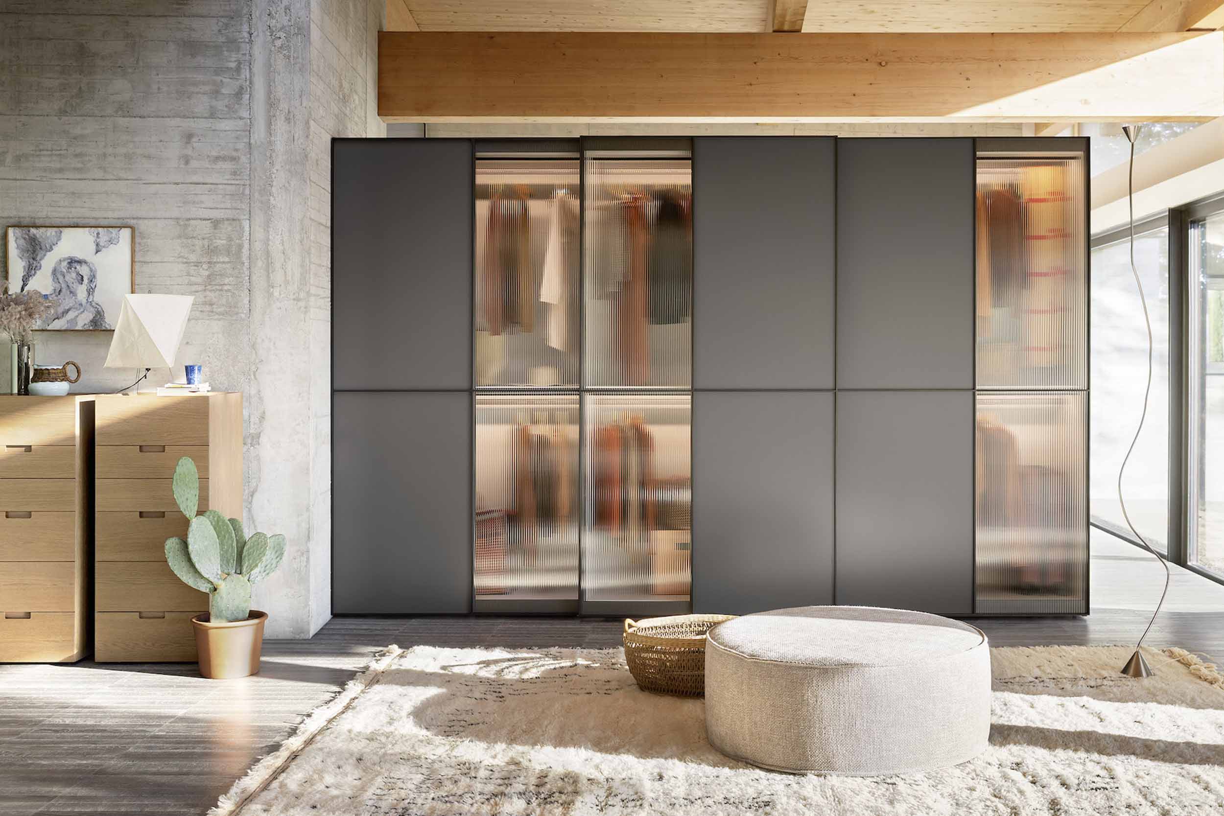 Modern, Italian sliding wardrobe with elegant glass panels, available with wired glass and smoked glass with matt lacquer. Designed and fitted by Krieder.