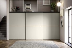 Luxury, minimal sliding wardrobe with central wooden insert. Italian wardrobes, designed and fitted by Krieder.