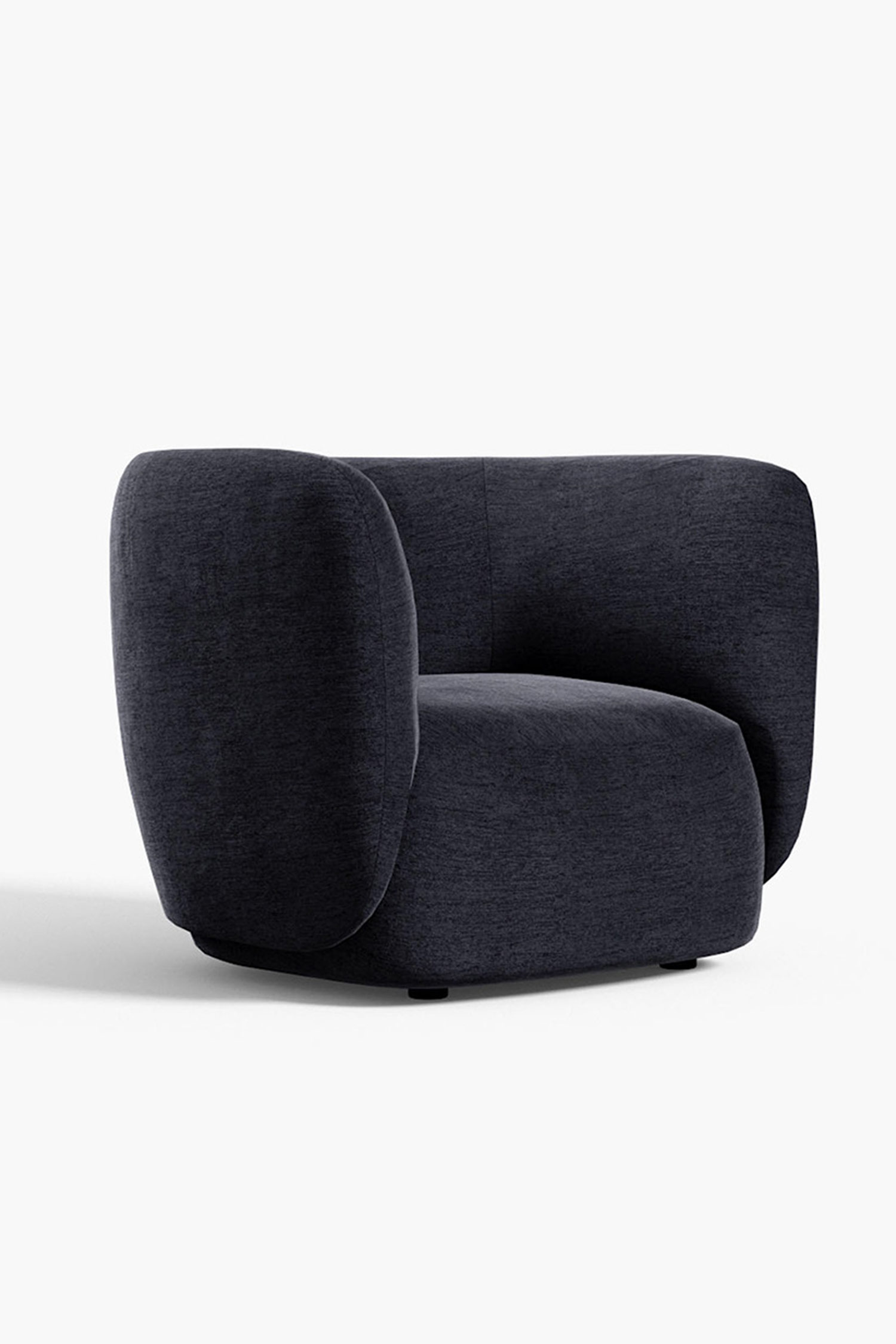 A low-angle view of a modern dark gray armchair with a curved back and armrests, angled slightly to the left. The chair has a solid, rounded base and is set against a clean white background. The fabric has a visible, subtle texture.