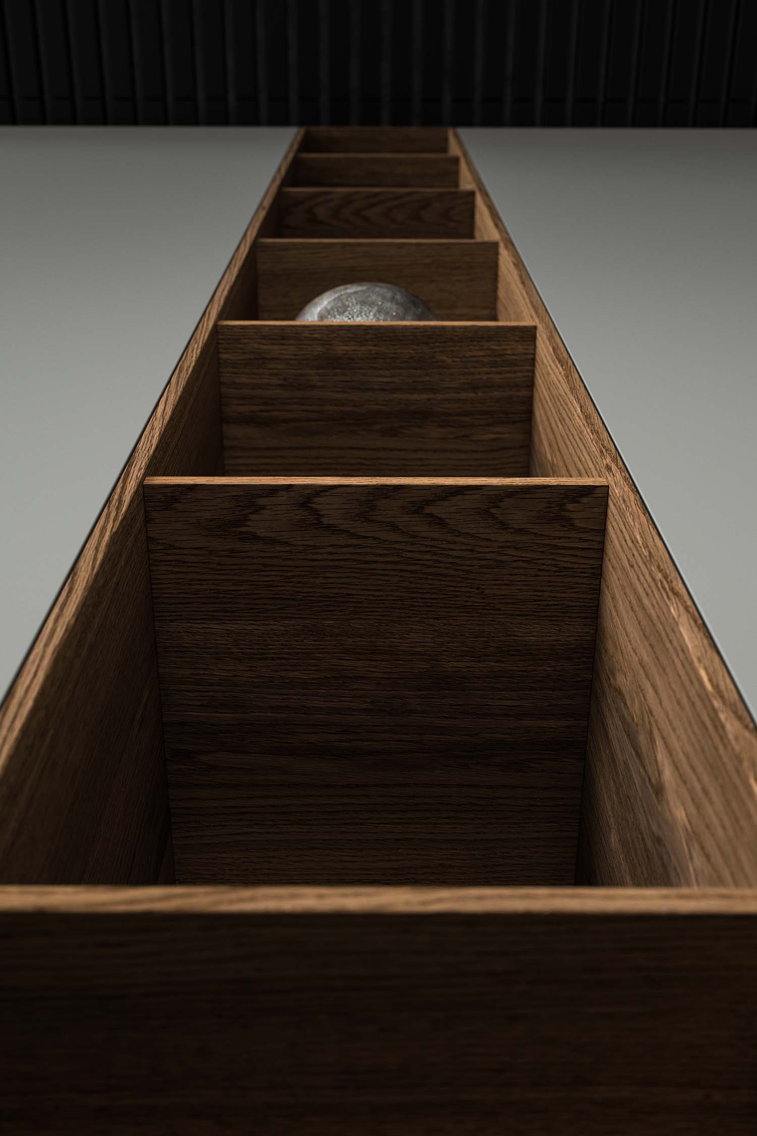 A detailed view of a black, handleless kitchen cabinet door with a matte finish. A thin, black linear indentation runs vertically down the cabinet, acting as a discreet handle.