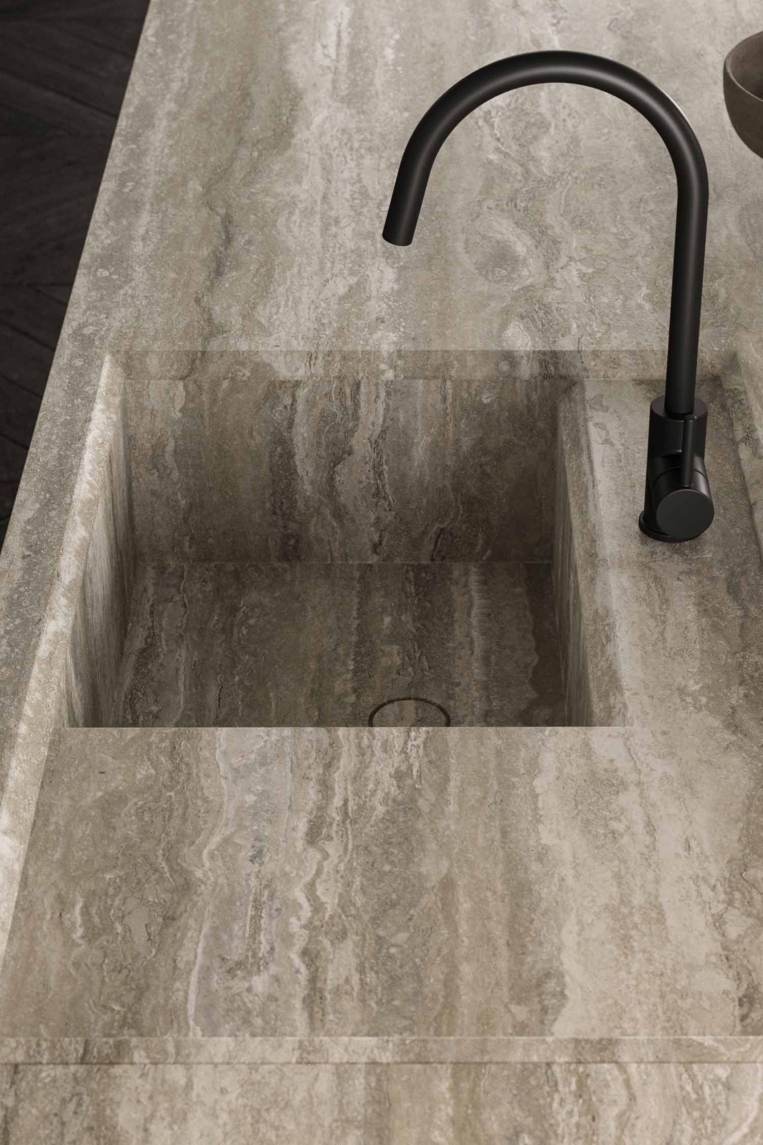 A detail shot of a kitchen cabinet's interior. The open cabinet reveals a light-colored wood interior with a glass shelf and a display of stylish glassware.