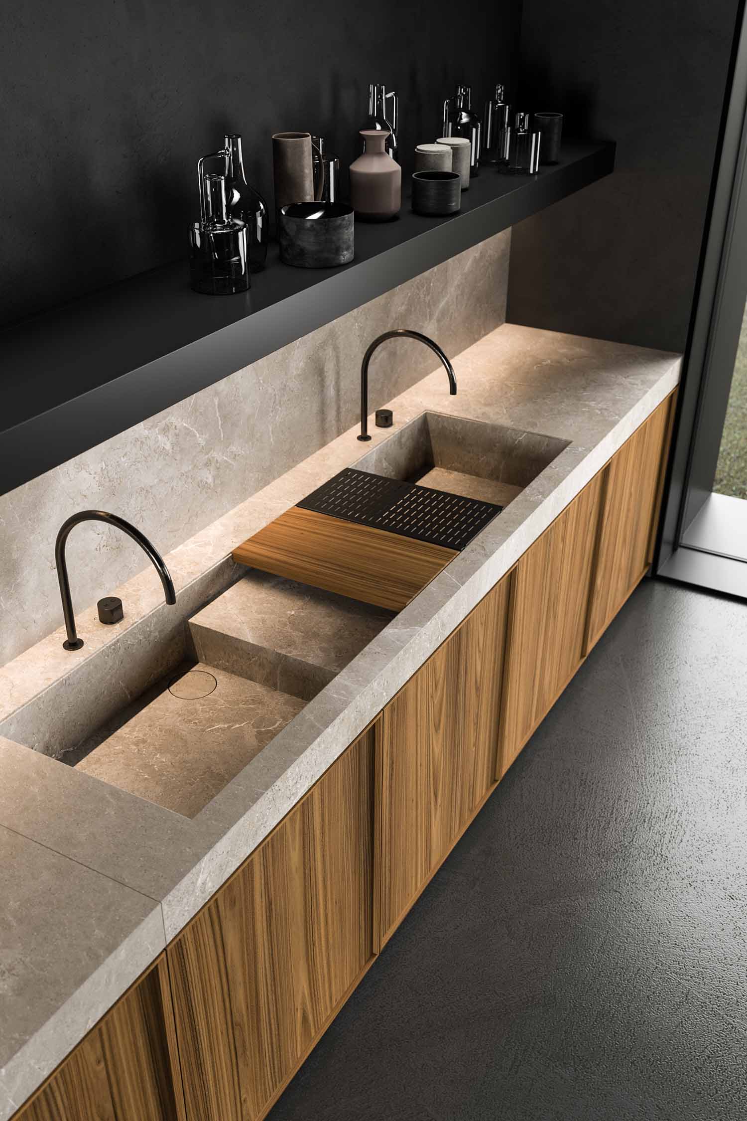 A close-up of a kitchen countertop and sink. The countertop is a dark, sleek material, and the sink is a modern, deep black basin with a matching black faucet. The image highlights the clean lines and minimalist aesthetic of the sink area.