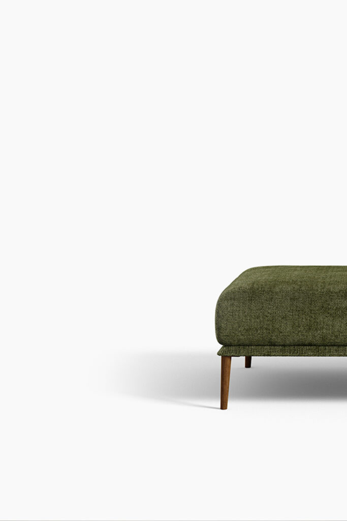A professional, low-angle studio shot of a modern, rectangular ottoman against a plain white background. The ottoman is upholstered in a dark olive green, textured fabric. The lower half of the ottoman and its splayed, rounded wooden legs are visible in the frame, casting a shadow on the floor.