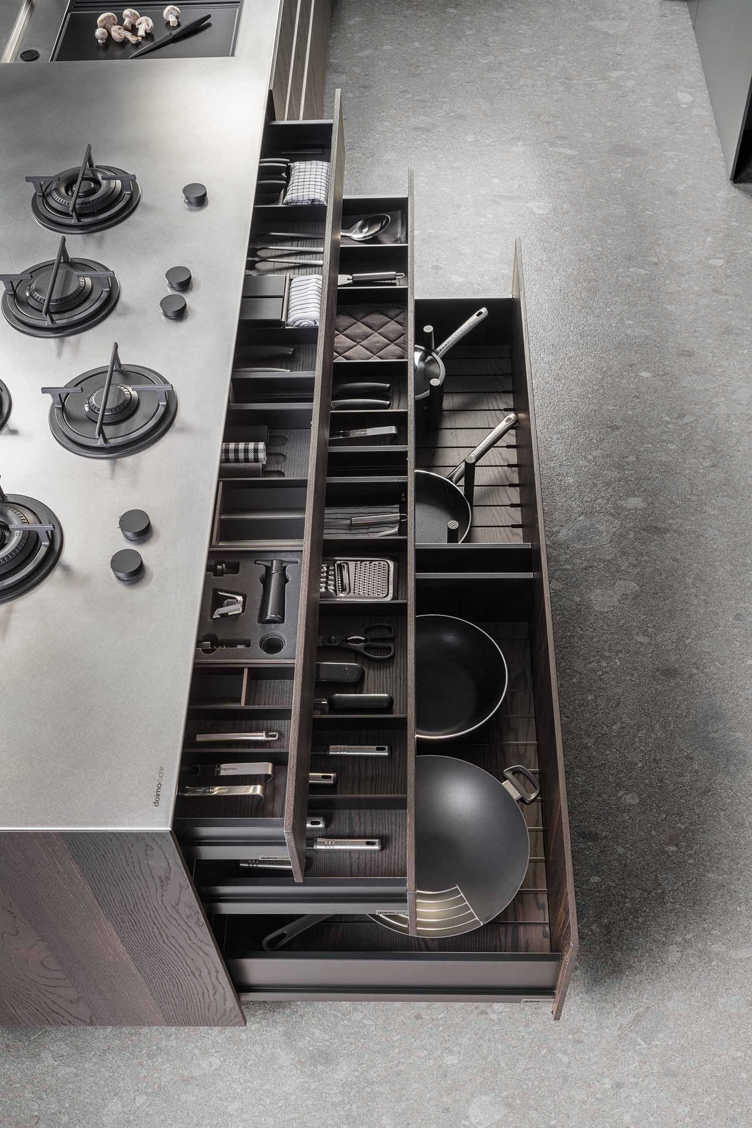A close-up of a kitchen wall featuring a sleek, integrated linear light strip on a dark, textured surface, possibly a backsplash or shelving unit.
