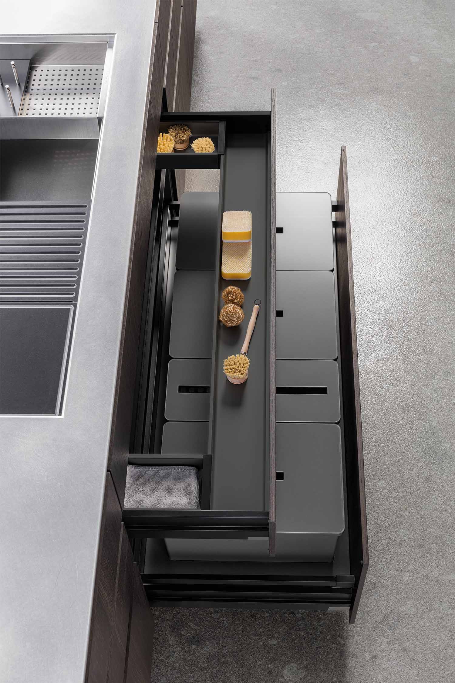 A side view of a minimalist kitchen cabinet with a curved, concave detail on the door's edge that acts as a subtle, integrated handle.