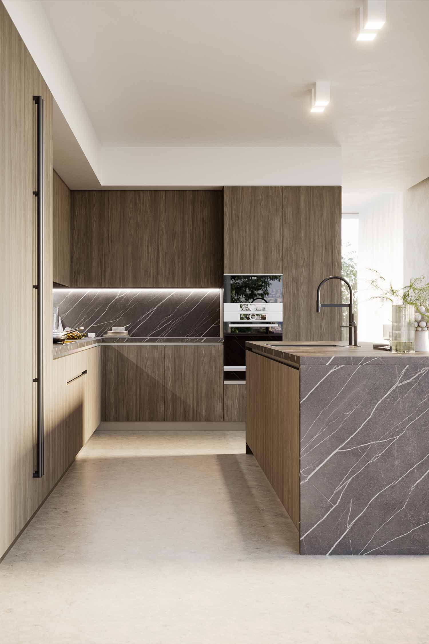 A detail shot of a modern kitchen island featuring an integrated hob and extractor fan. The hob is black glass, seamlessly set into a light-colored countertop. A stainless steel pot is on the hob, with a dark, textured wall behind it.