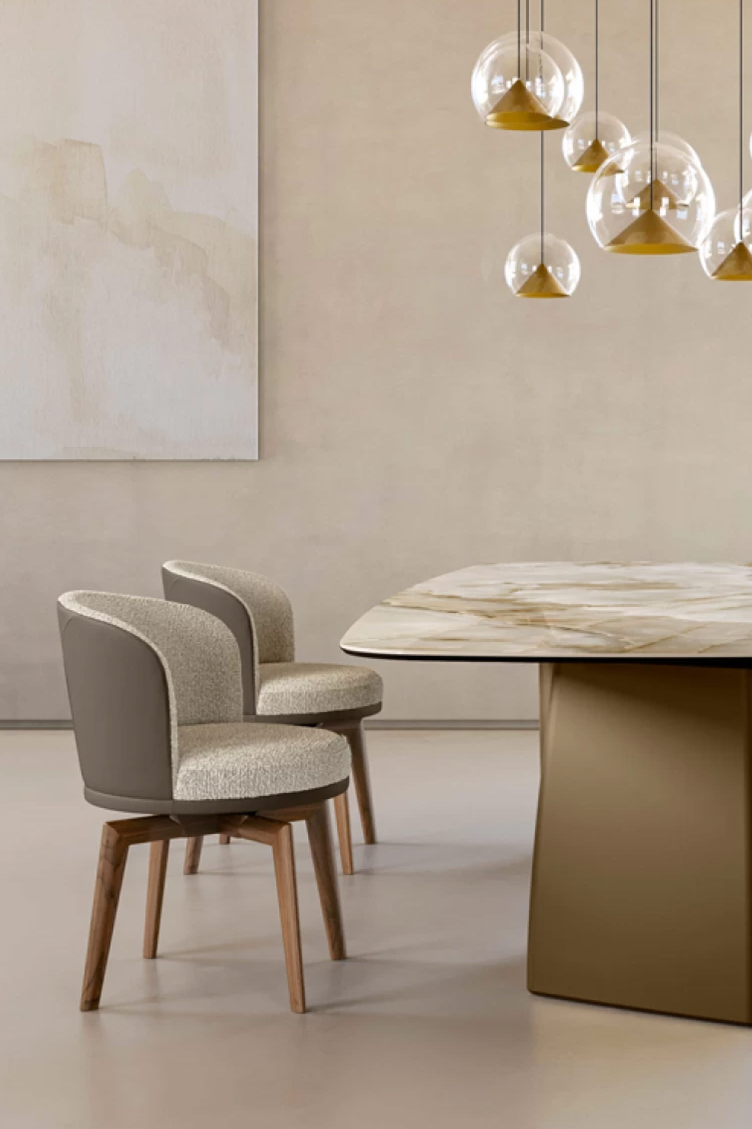 A close-up view focusing on the corner of a luxury dining table with a glossy, gold-veined marble top and a large, matte bronze pedestal base. Two upholstered dining chairs with rounded backs, featuring beige textured fabric and a taupe leather exterior, are visible. The chairs have wooden swivel bases. A cluster of glass globe pendant lights with gold interior cones hangs overhead against a light beige wall.