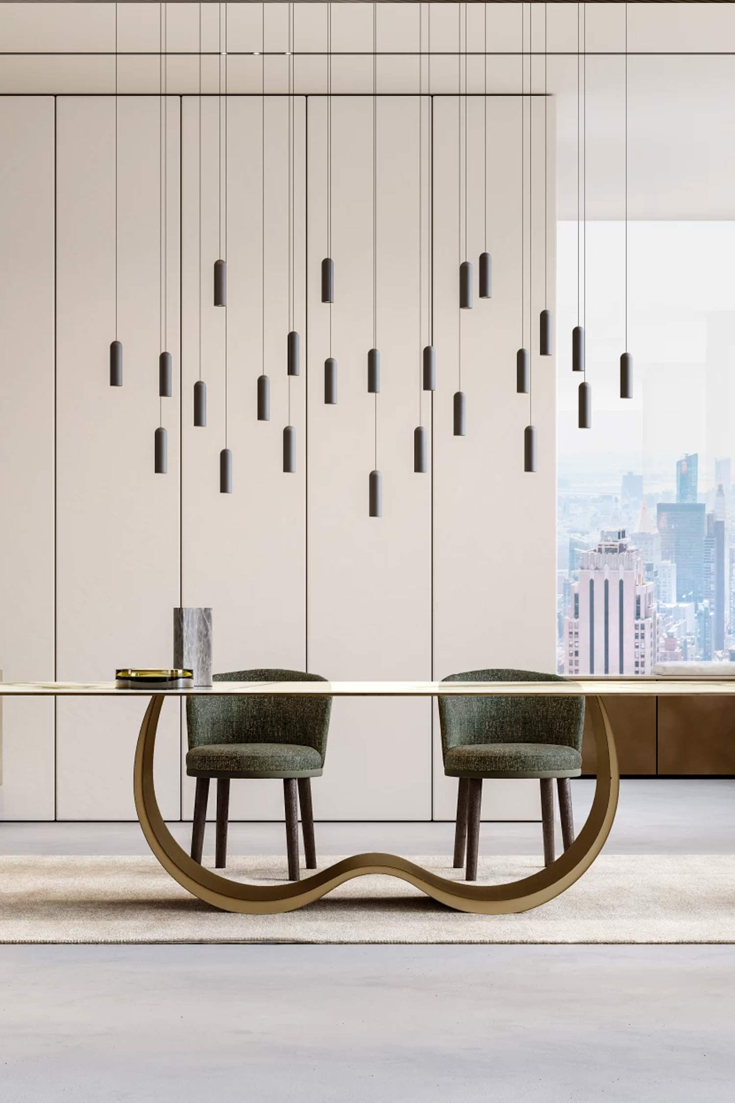 A frontal view of a modern dining room focusing on the Alisei dining table with its thin, elegant tabletop and wavy, gold-colored metal base. Two dark green upholstered dining chairs are visible. The room features a wall of vertical light panels and a dramatic installation of multiple thin black pendant lights hanging above the table, with a city skyline visible through the window.