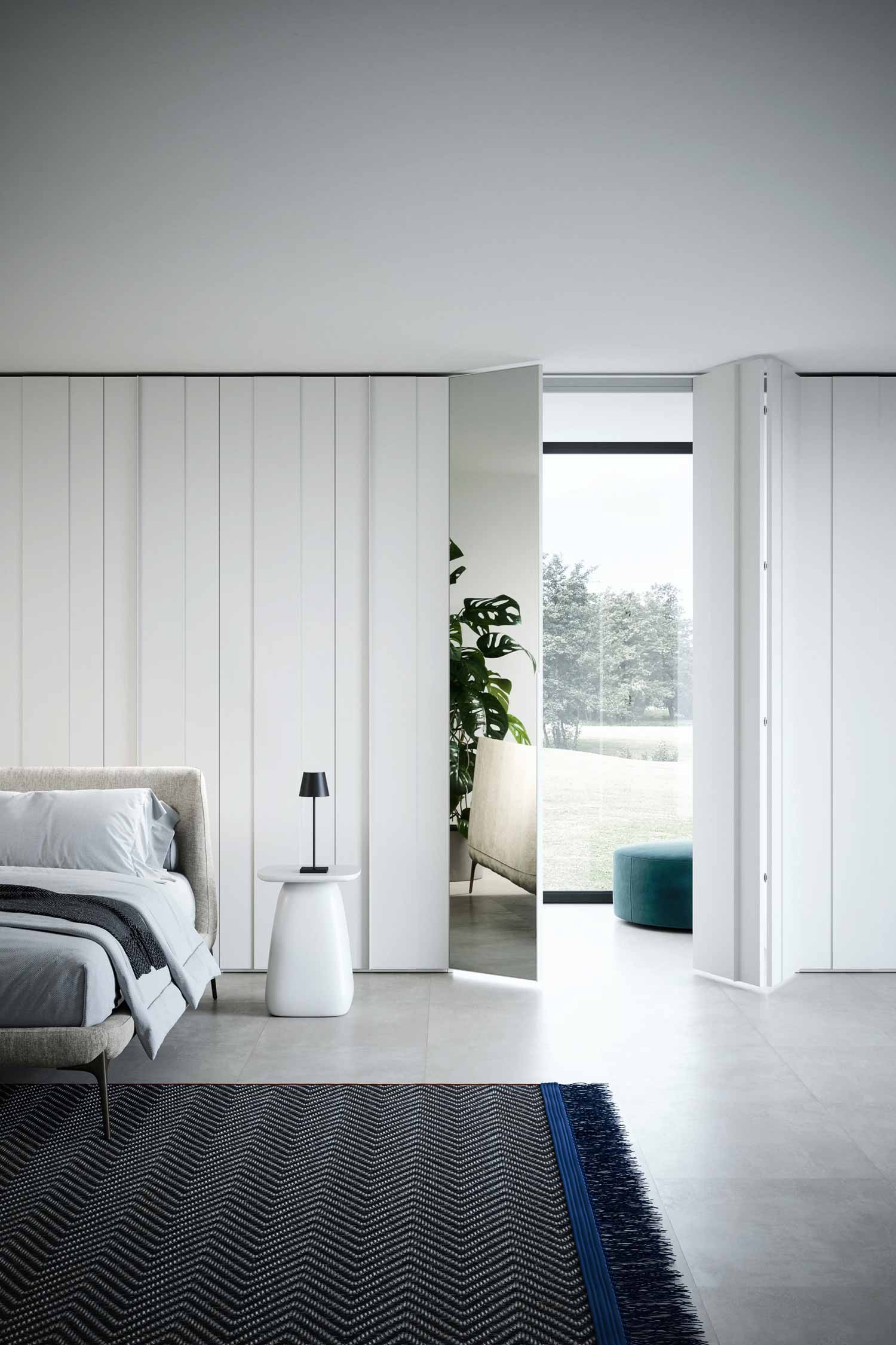Here are the alt tags for the final set of images. Crystal-luxury-hinged-wardrobe-Krieder-studio-Detail-007.jpg A minimalist bedroom with a large, white paneled wardrobe. One door is open, revealing a mirror that reflects a window and the outdoor landscape. The room has a large bed, a white side table with a black lamp, and a blue and white patterned rug on gray tiled floors.