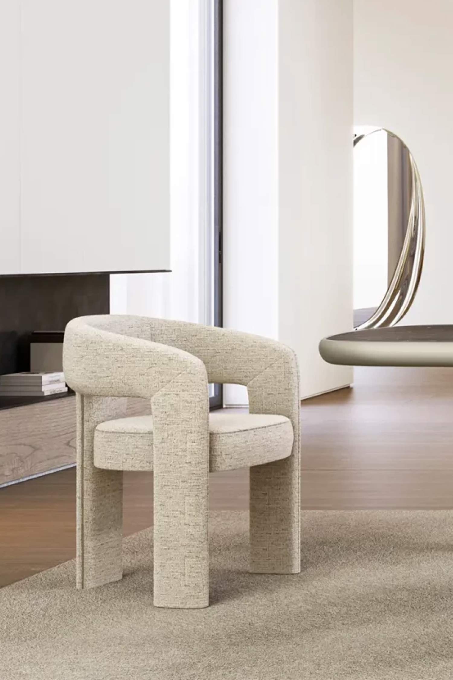 A close-up shot of a single Egle dining chair upholstered in a light, textured fabric with subtle stitching details. The chair is placed on a beige rug in a modern, neutral-toned room. In the background, there's a dining table, a unique mirror, and a sleek credenza, showcasing the chair in a luxurious home setting.
