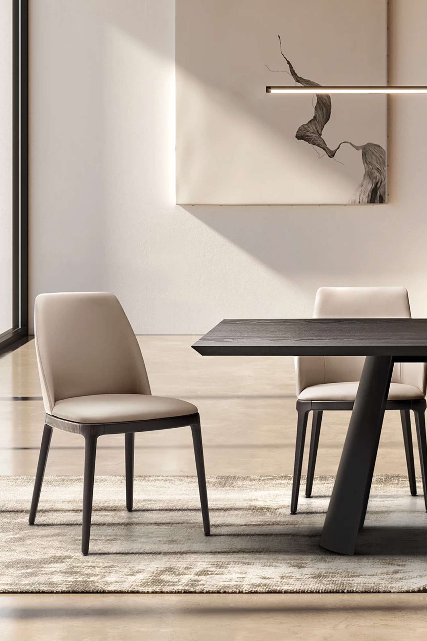 Two Max armless dining chairs with light beige upholstery and dark wood frames flanking a long dark wooden rectangular dining table in a contemporary setting.