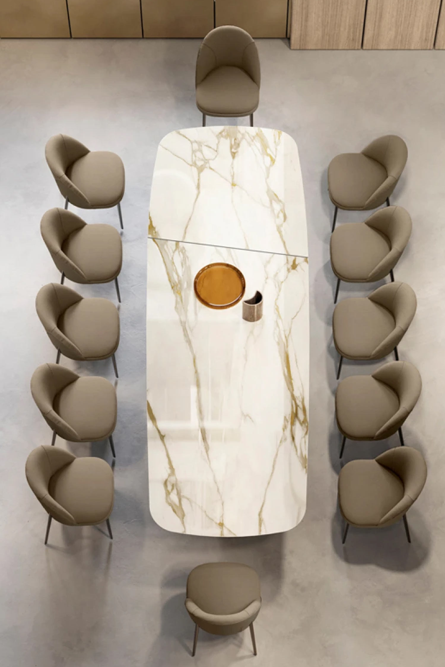 A bird's-eye view of the Teo extendable dining table set for twelve people. The tabletop has a white and gold marble-look finish, clearly showing the seam where the leaf is stored or extended. Ten tan upholstered chairs line the sides, with two additional chairs at the head and foot of the table.