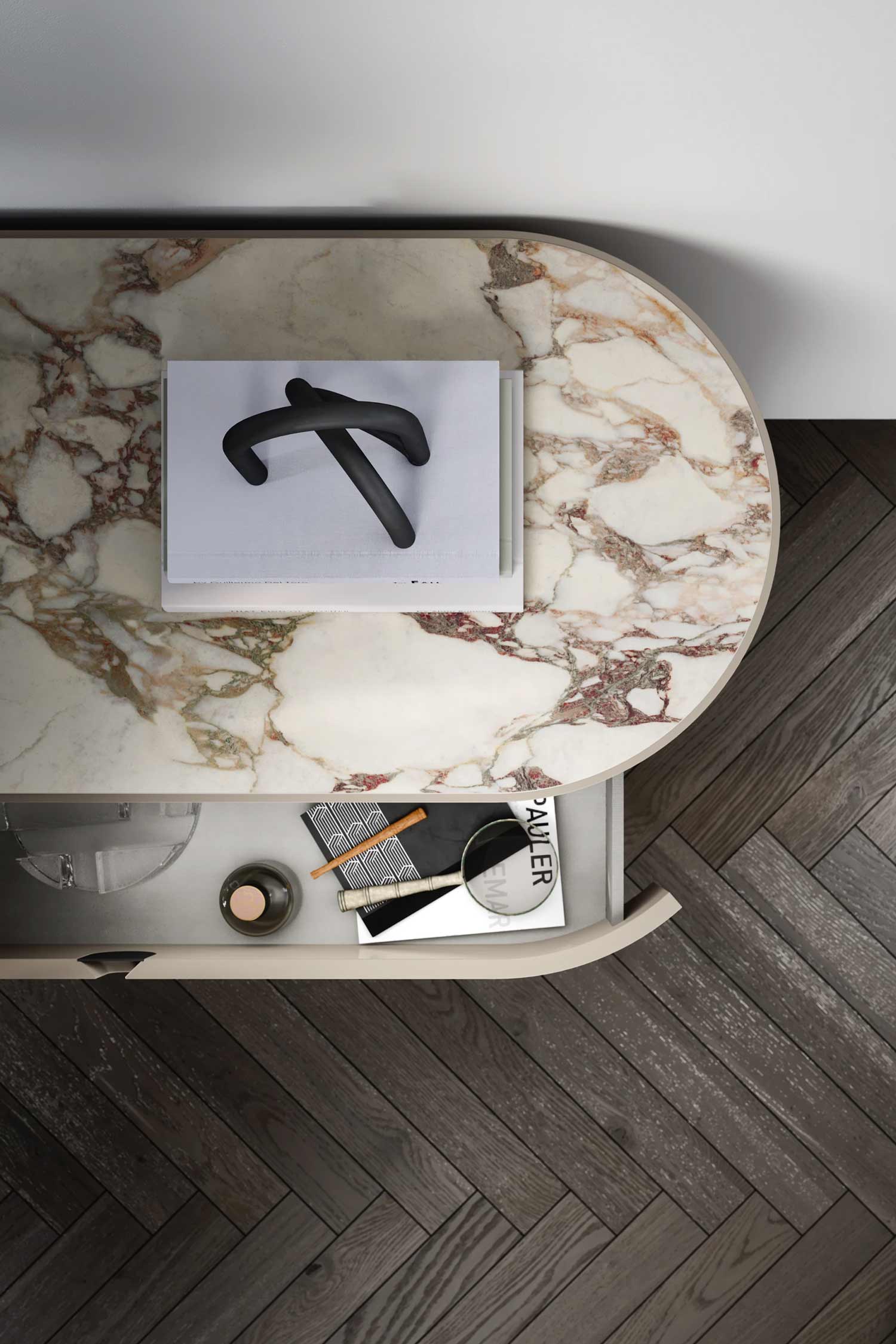 Overhead detail shot of a Vesta luxury drawer nightstand with a rectangular, marble top and an open drawer showing internal organization with a magnifying glass and small accessories.