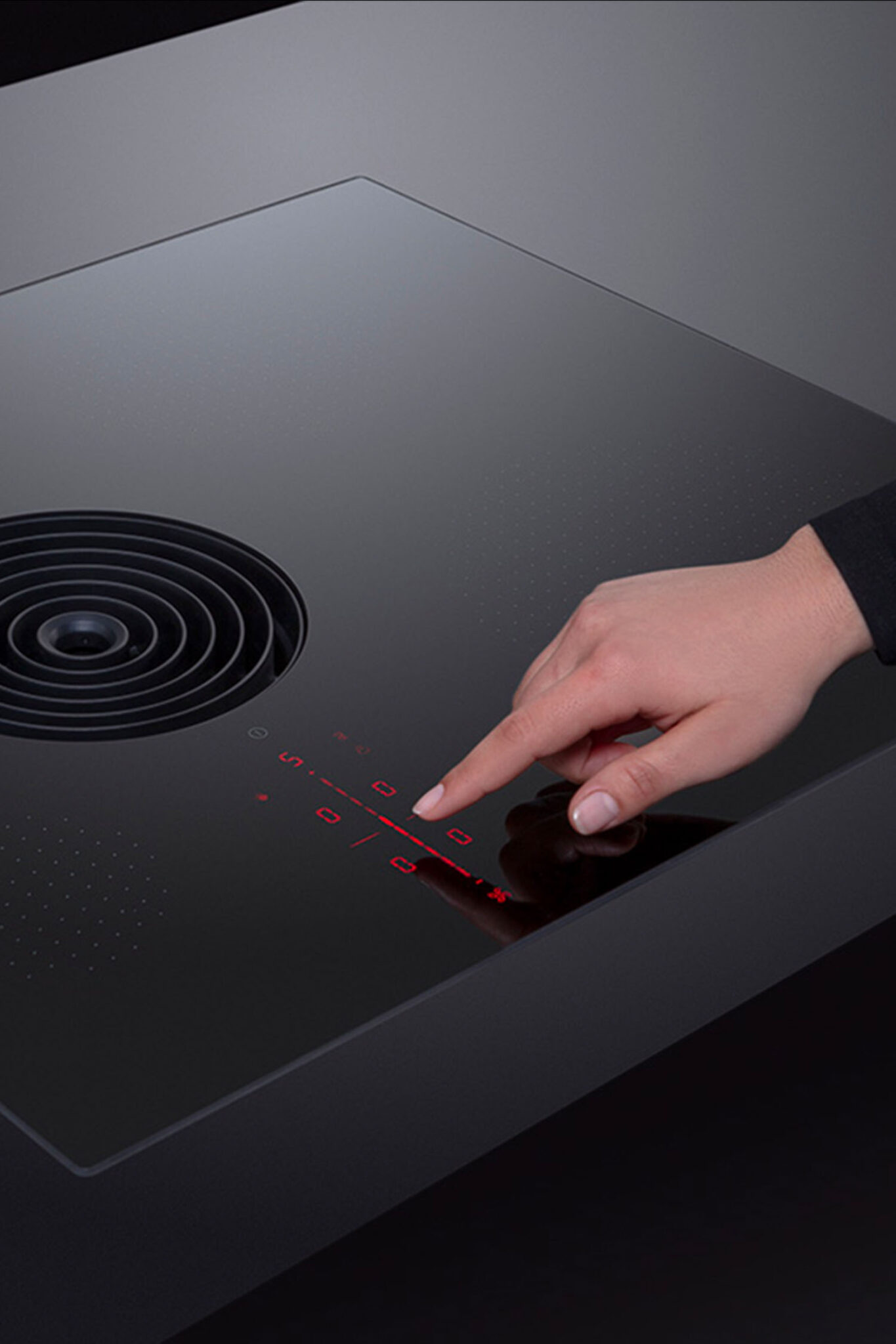 Hand adjusting the touch slider controls on a BORA Pure S cooktop.