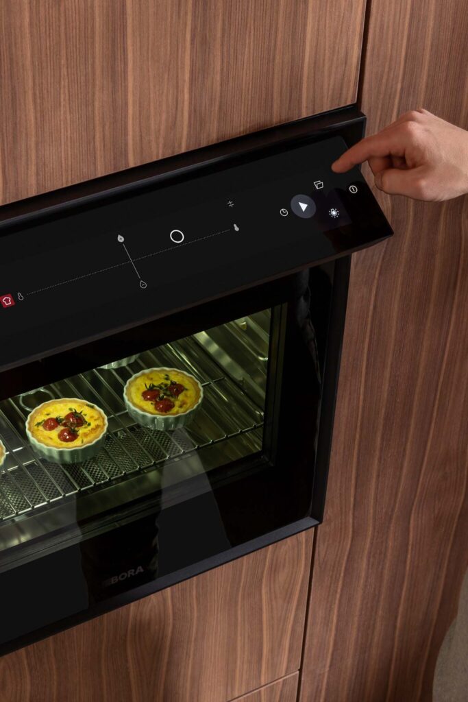 Two dishes cooking simultaneously inside BORA X BO steam oven, showing even heat and steam distribution.