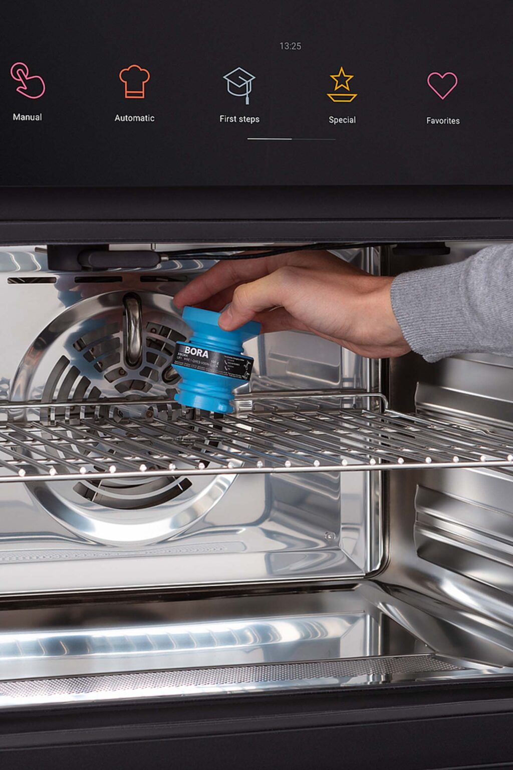 Interior of BORA X BO steam oven showing water container and stainless cavity for precise humidity control.