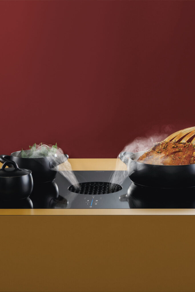 BORA X Pure induction hob with integrated extractor efficiently removing steam while multiple pans cook on sleek surface.