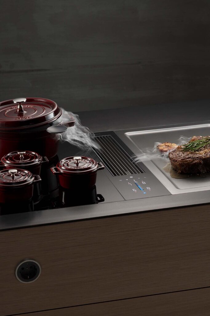 Two red pots simmering on a BORA Classic cooktop with steam drawn neatly into the centre vent.