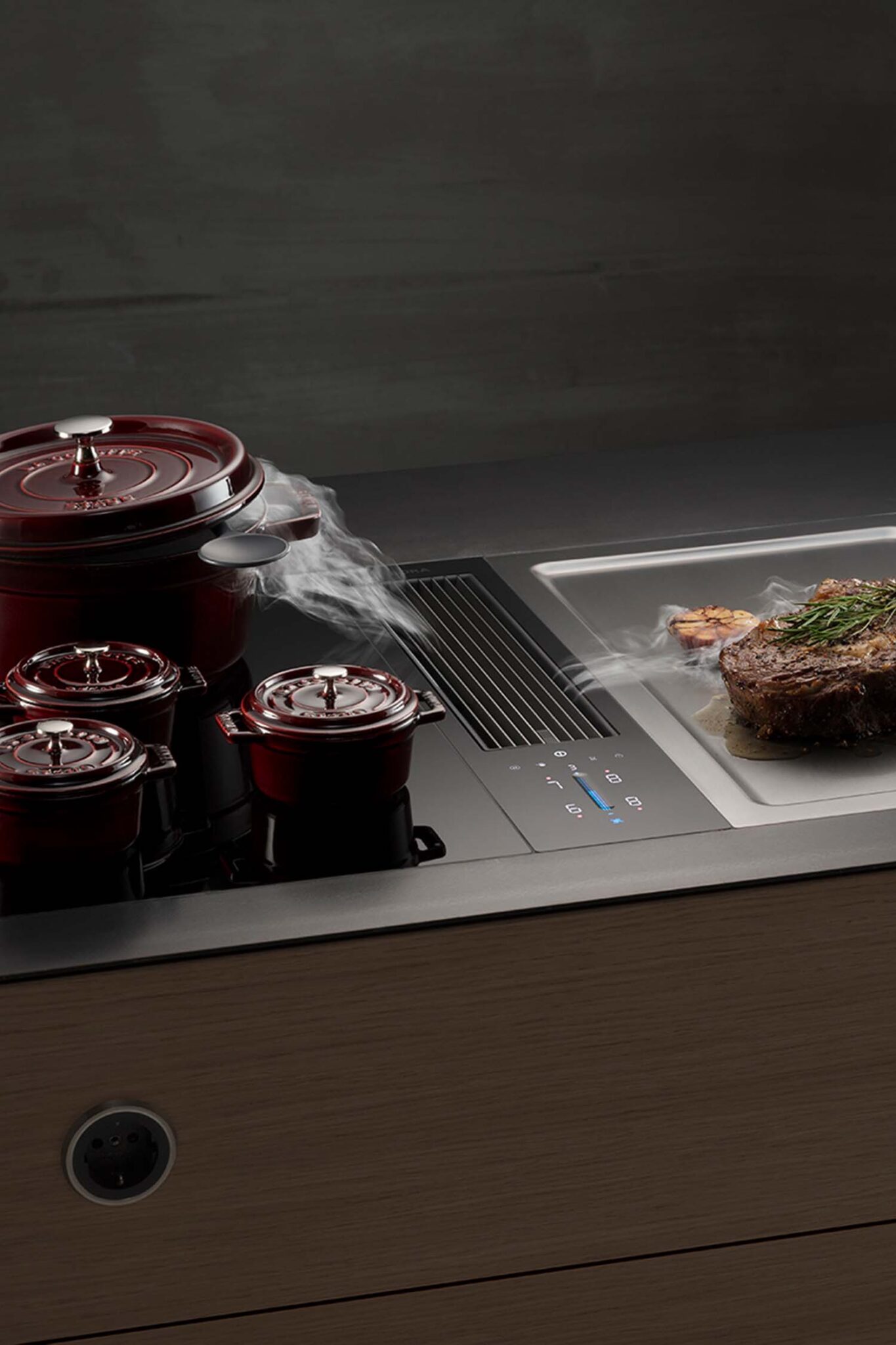 Two red pots simmering on a BORA Classic cooktop with steam drawn neatly into the centre vent.