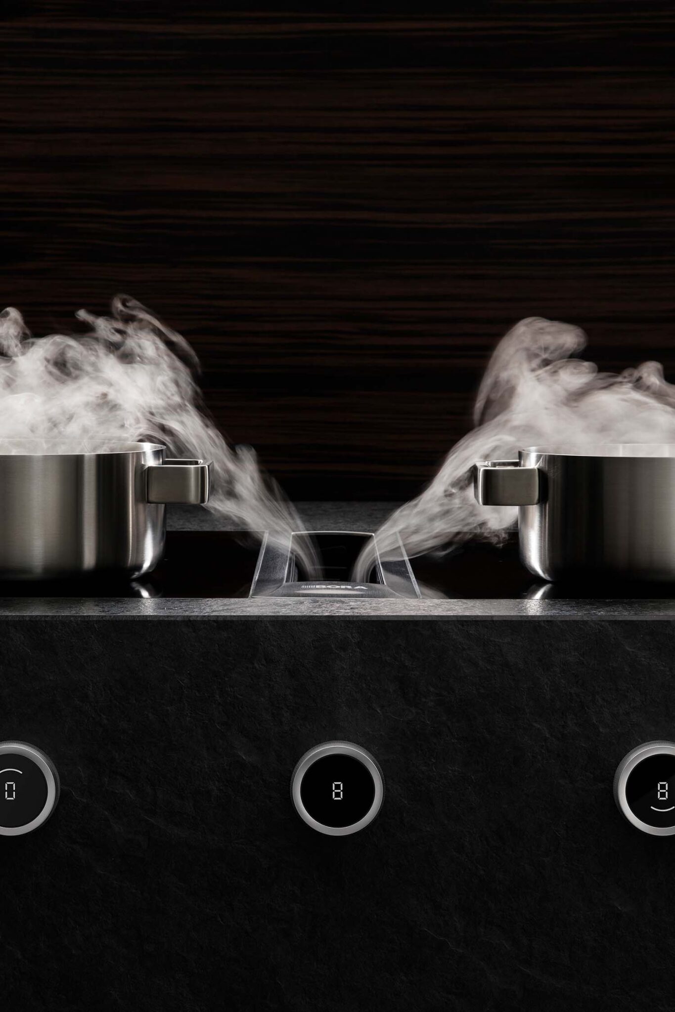 Steam rising from twin pans above a BORA Professional extractor vent built into the hob.