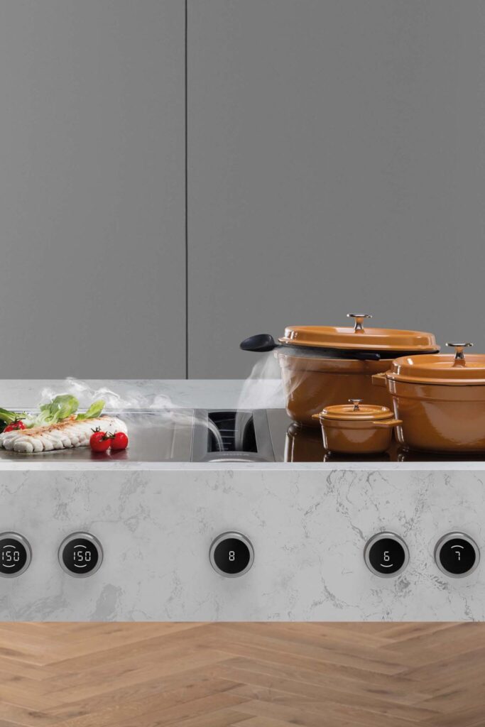 Copper pots simmering on a BORA Professional cooktop set into a marble countertop.