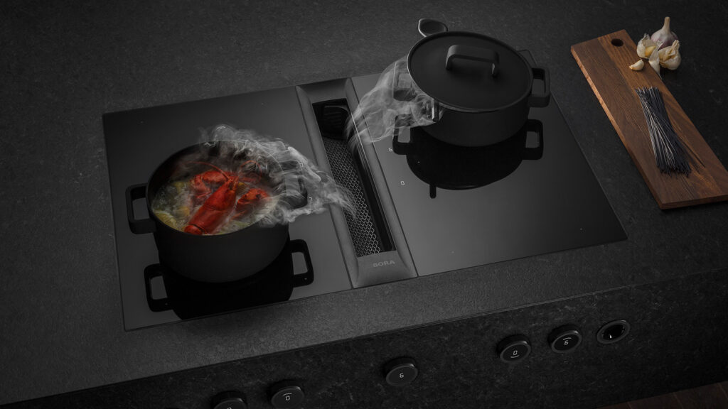 Black pot and red pan in use on a BORA Professional cooktop with steam visibly drawn downward.