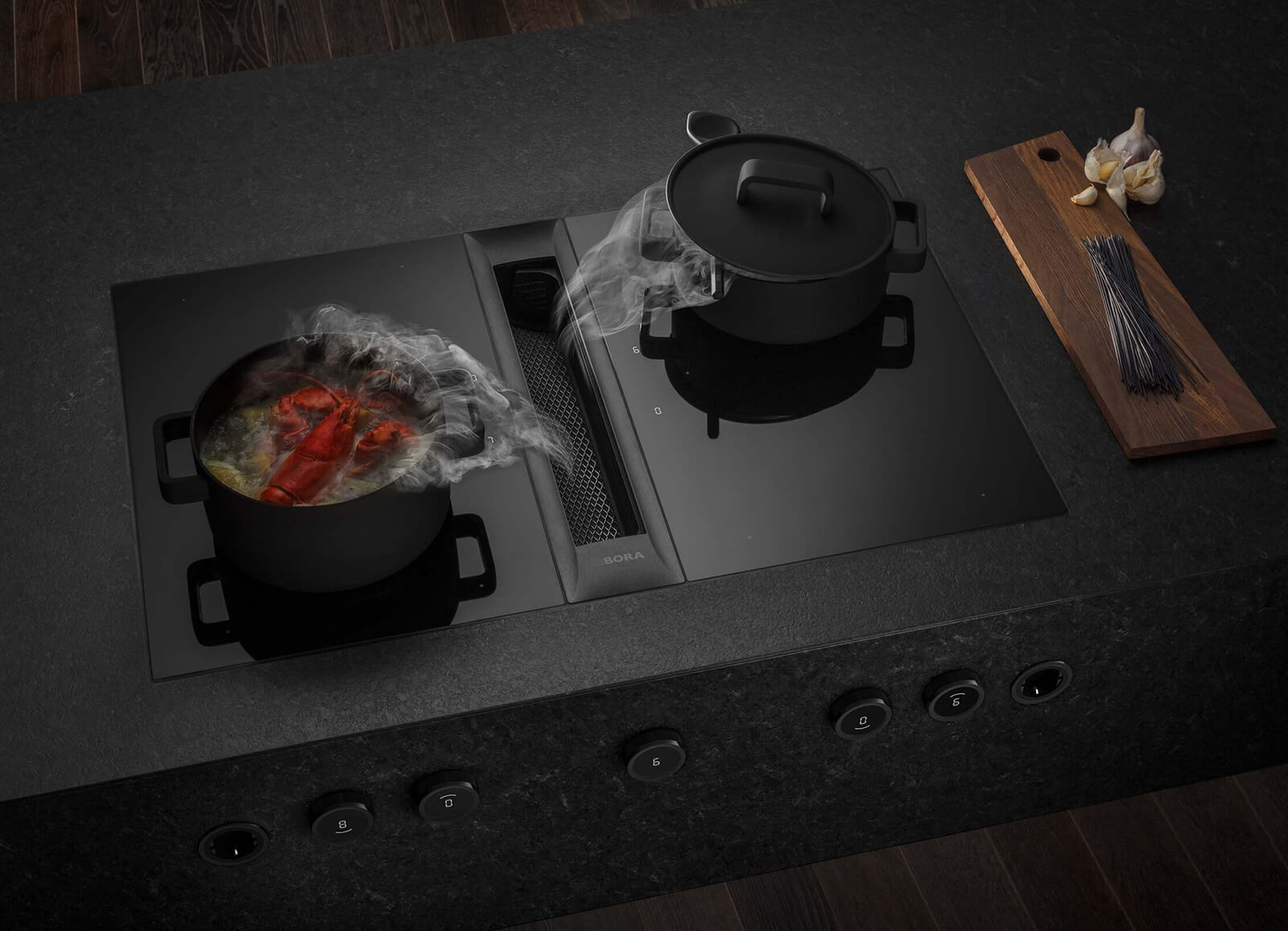 BORA Professional installed into a luxury black kitchen, showcasing industrial style downdraft extraction.