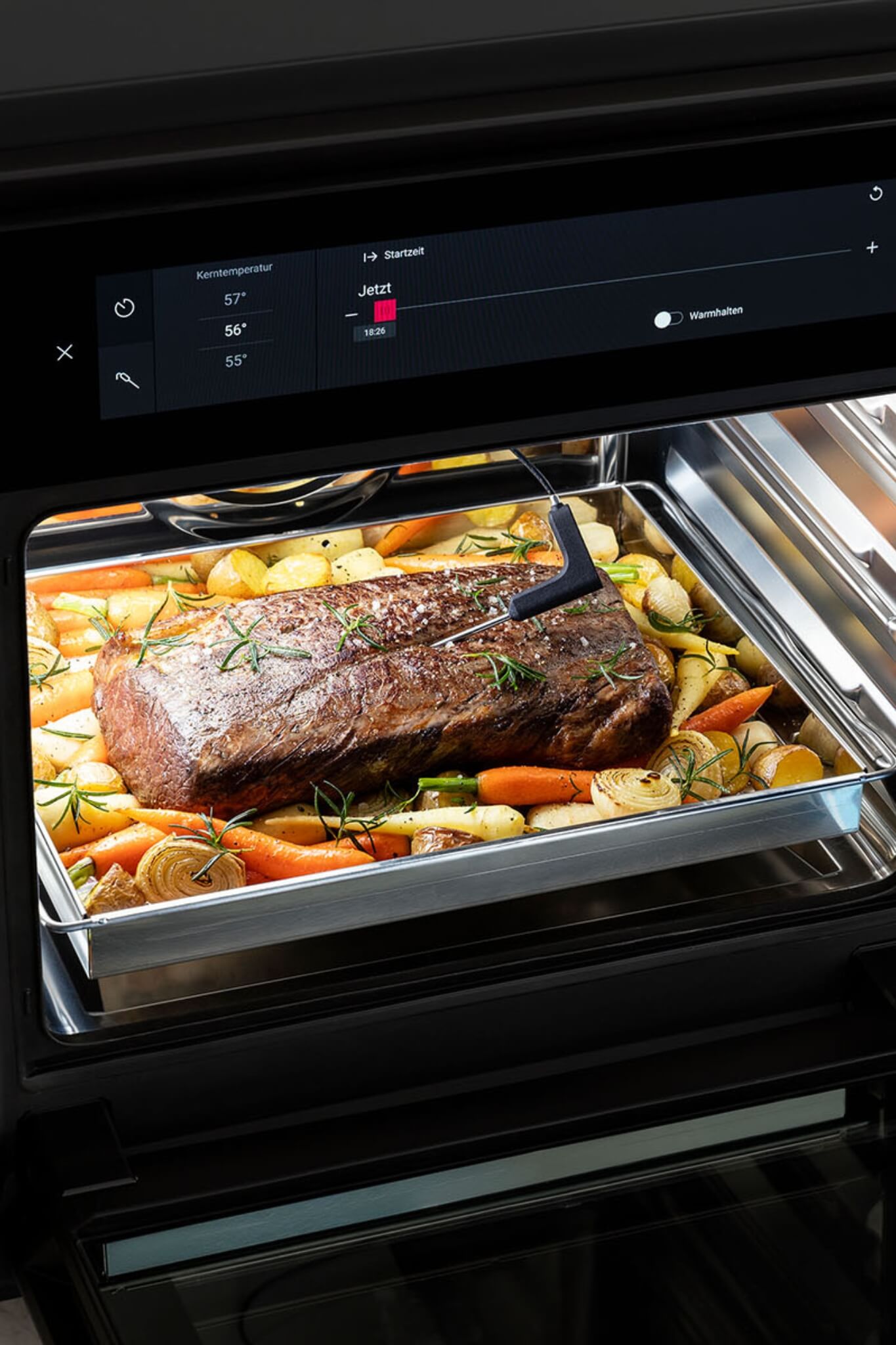 BORA XBO oven roasting beef joint with carrots and potatoes in enamel tray.