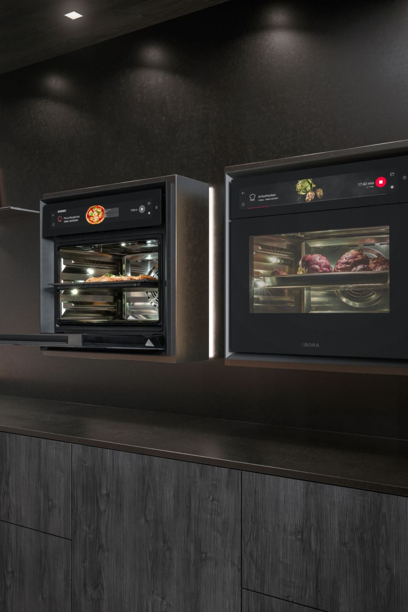 Two BORA XBO ovens side by side, filled with roasting trays of chicken and vegetables.