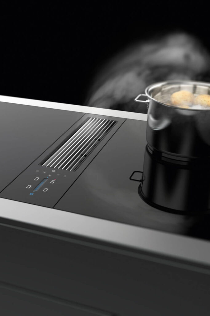 Steam rising from boiling pot on BORA Classic cooktop with slim central extractor.
