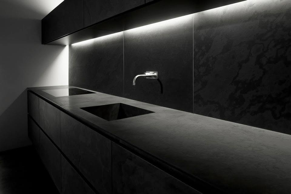 Dark luxury kitchen with integrated sink and wall-mounted tap